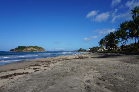 Pláž s čiernym pieskom v mestečku Sainte-Marie, v pozadí ostrovček Îlet Sainte-Marie