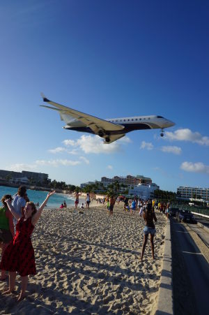 Lietadlo pristáva ponad pláž Maho na letisku princeznej Juliany na ostrove Svätý Martin