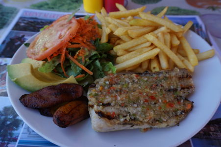 Grilovaná ryba mahi-mahi, obľúbená v celom Karibiku. Karibská kuchyňa často dopĺňa jedlá o malé opečené banány (vedľa ryby)