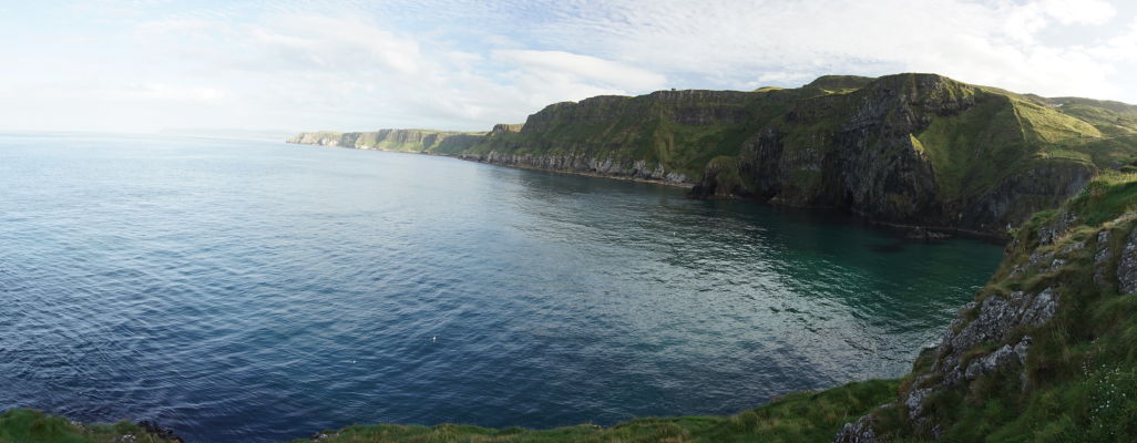 Pohľad na útesy, ktoré tvorili kedysi kráter sopky, z ostrova Carrick-a-Rede