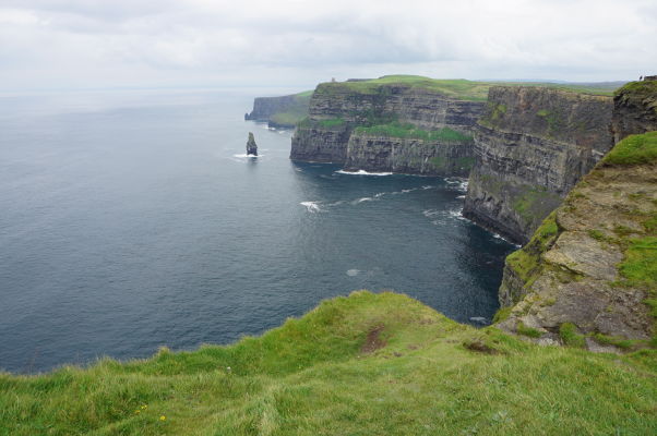 Moherské útesy (Cliffs of Moher) na západnom pobreží Írska - v diaľke vidieť O'Brienovu vežu a pod ňou skalisko Branaunmore trčiace z mora