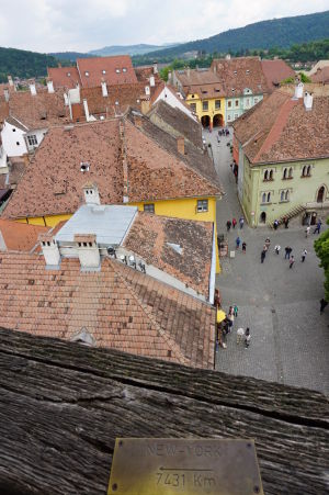 Na zábradlí balkóna sa nachádzajú štítky označujúce smer a vzdialenosť k niektorým svetovým mestám