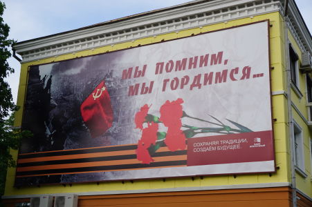 Propagandistický bilboard zobrazujúci vyvesenie sovietskej vlajky na budove Reichstagu